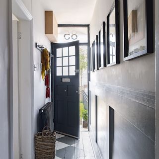 house entrance with white wall frames on wall and navy blue door with letterbox flap