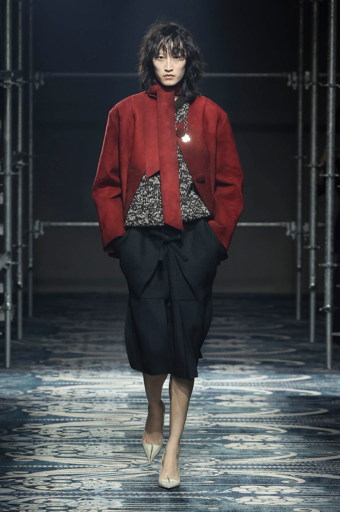 Chaqueta roja de pasarela Prada primavera/verano 26, falda negra, zapatos de tacón blancos de piel envejecida