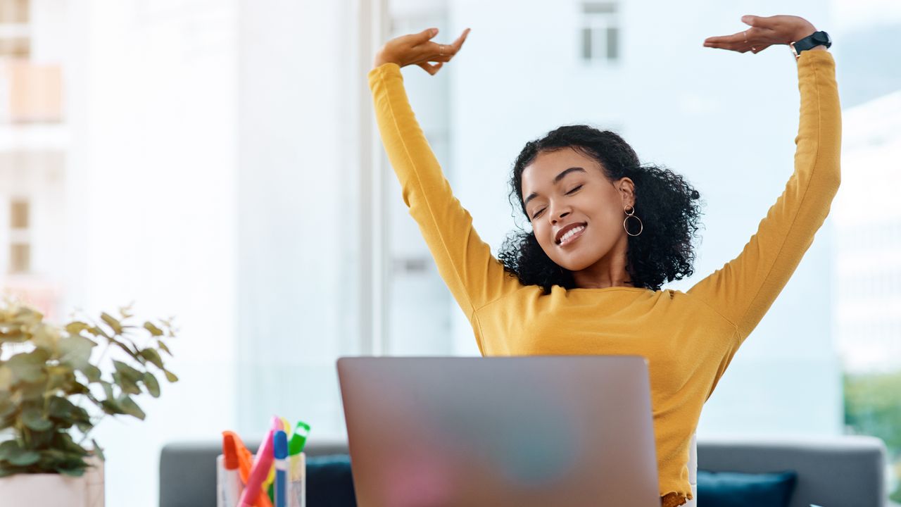 Woman sitting at a desk stretching