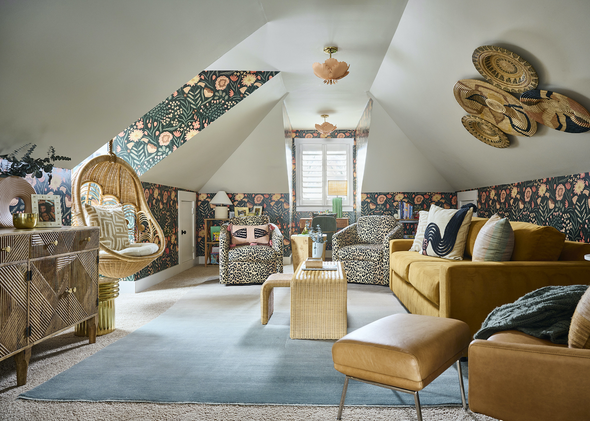 loft conversion with mustard sofas and wallpaper and blue rug