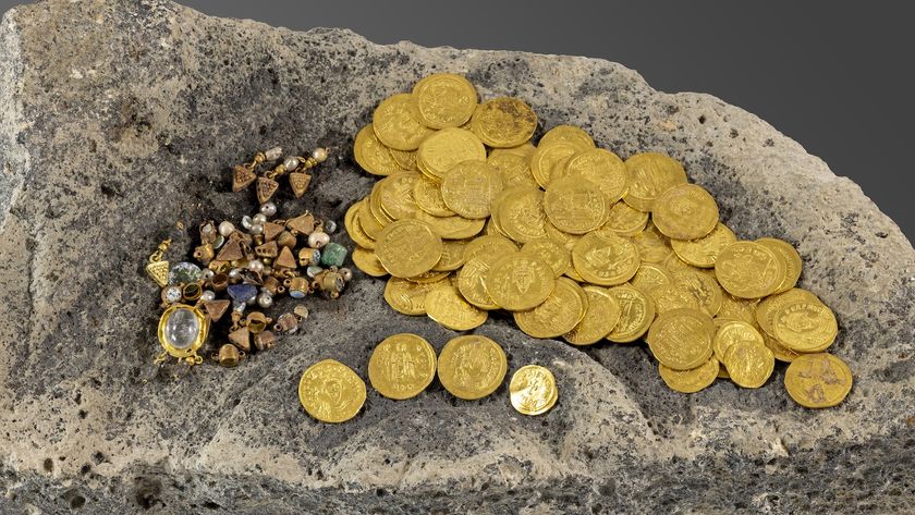 a pile of gold coins and jewelry on a rock