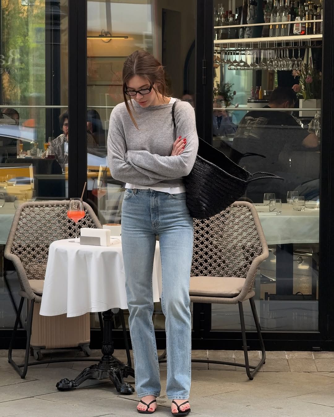 woman wearing straight-cut jeans and grey sweater and flip flops