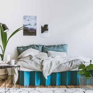 room with white wall and blue cardboard bed