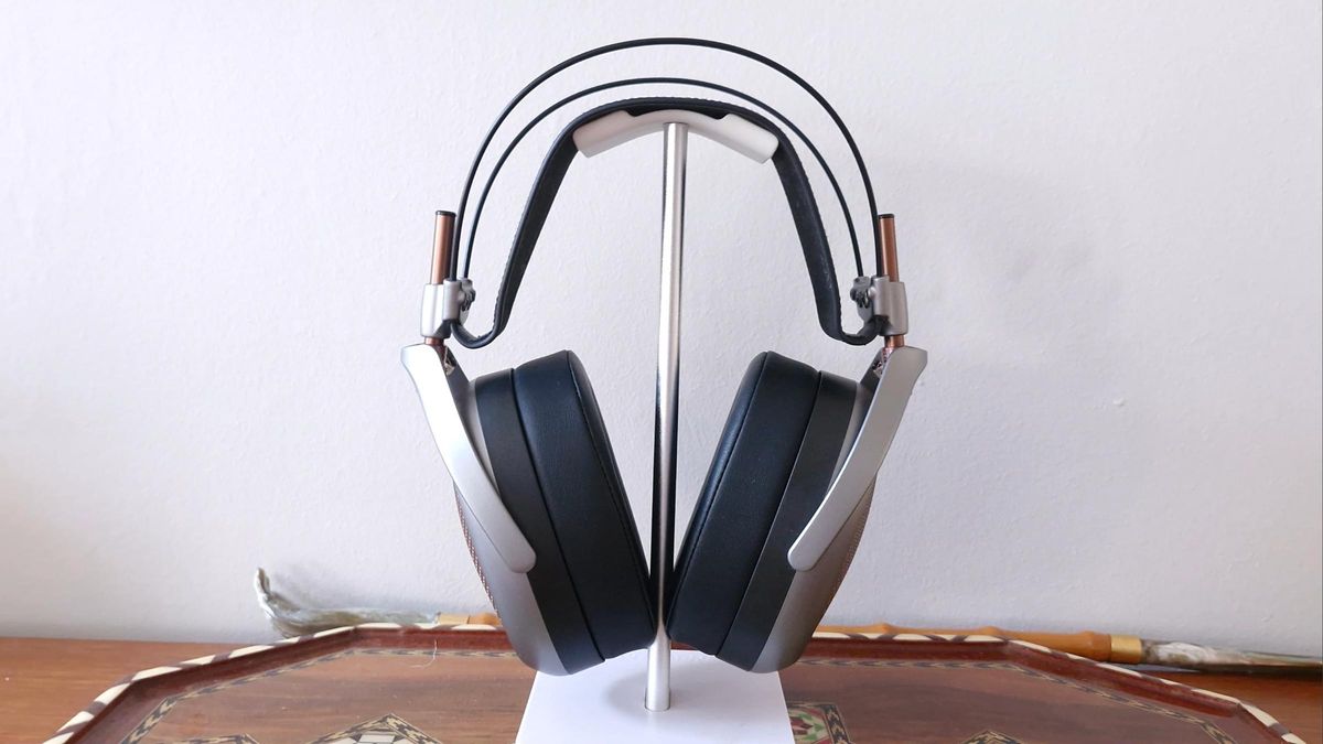 Meze Audio Poet open-back over-ear headphone on a stand, placed on a wooden table tray