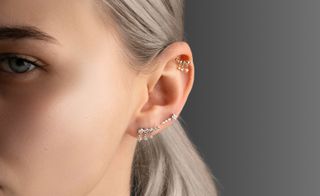 side of woman's face with multiple earrings in ear