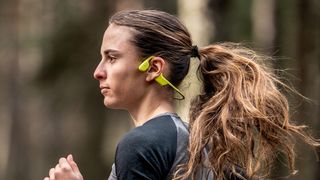 Woman running wearing Suunto Sonic headphones