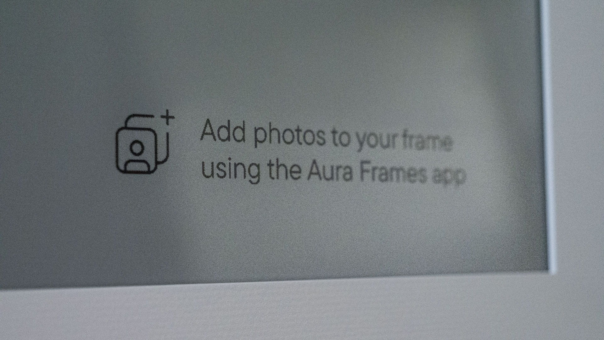 A closeup of the Aura Ink 'E Ink' digital photo frame's display, in pairing mode