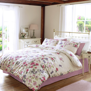 bedroom with wooden flooring and floral printed white bedding set on bed