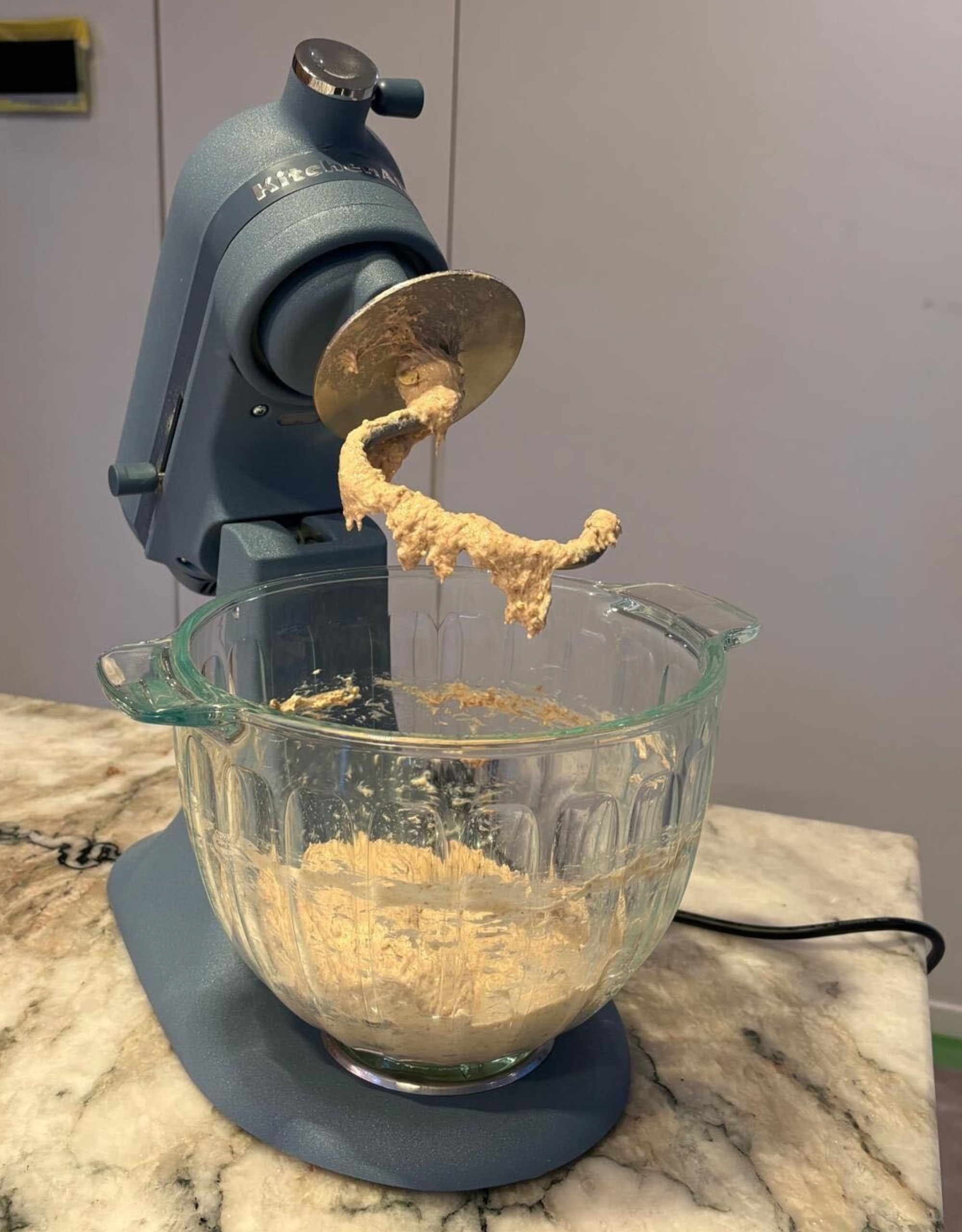 The kitchenaid luminaire with the dough hook and bread dough in the bowl