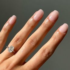 A close up of a sheer pink manicure