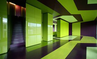 Interior room with black and bright green graphic floor, walls and ceiling, black stairwell