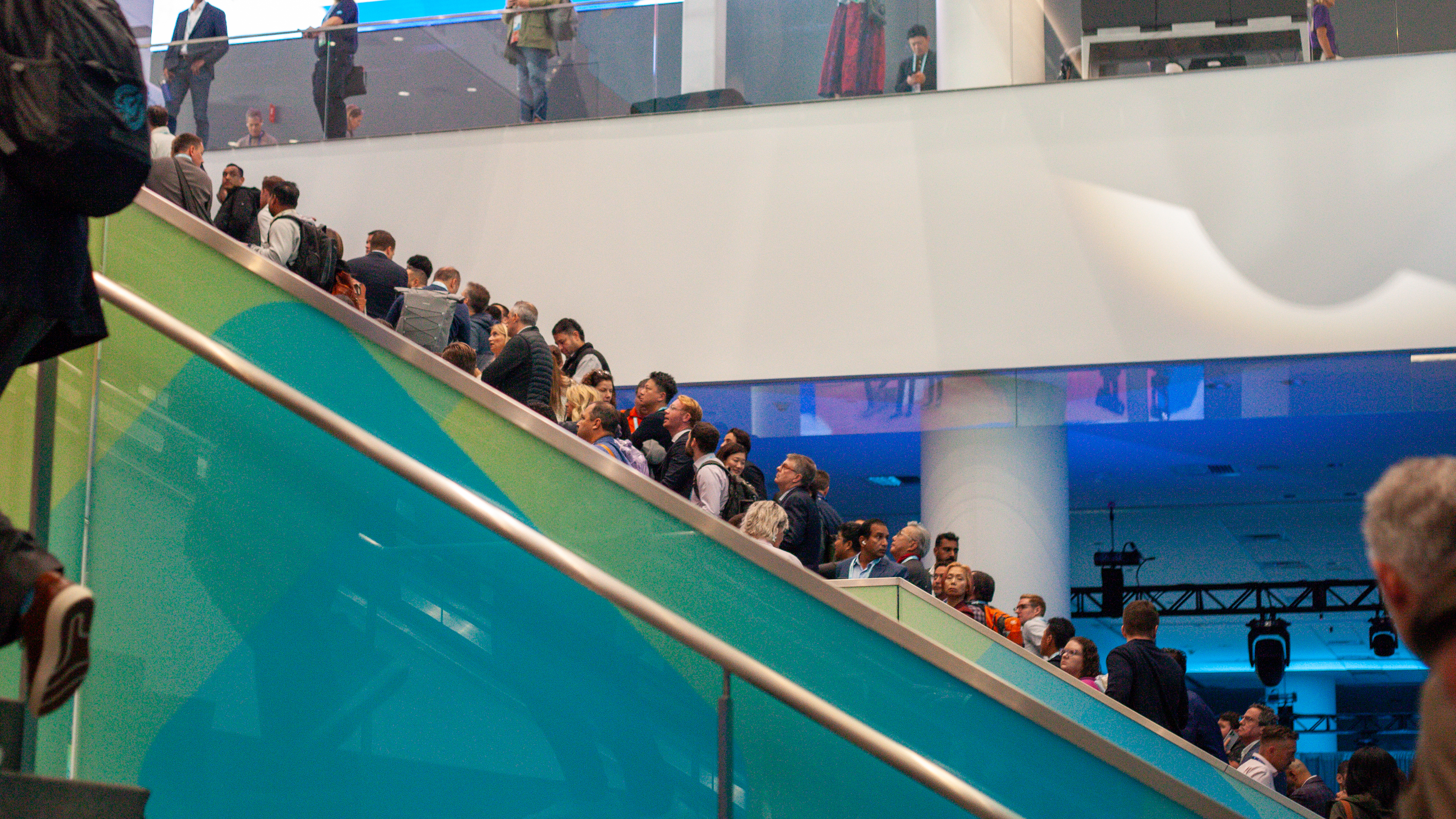 Dreamforce 2025 attendees on an escalator within the Moscone Center, San Francisco.