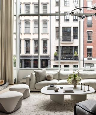 A textured rug in a large living room with a white sofa and floor-to-ceiling windows