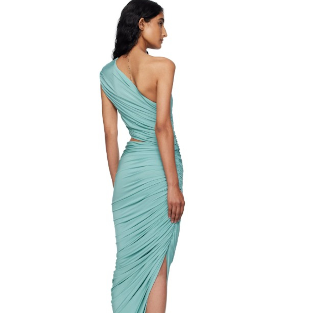 A model posing with their back to the camera in a one-shoulder teal wrap dress with a low leg slit