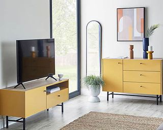Yellow TV stand in modern interior with matching yellow sideboard
