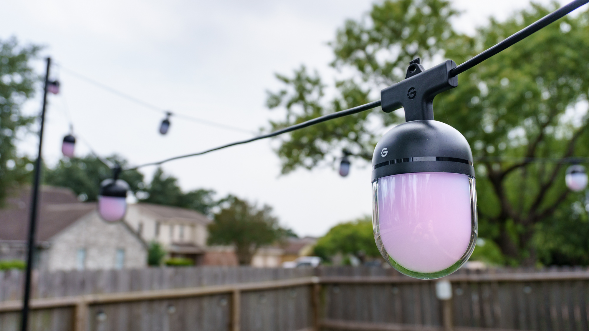 A set of Govee Outdoor Chromatic String Lights installed in a yard and lit up during the day