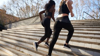 Two sportswomen during workout on stairs - stock photo