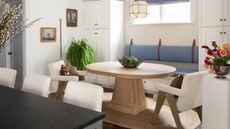 Breakfast nook with white walls and cabinets, round breakfast wood table, banquette seating and jute rug