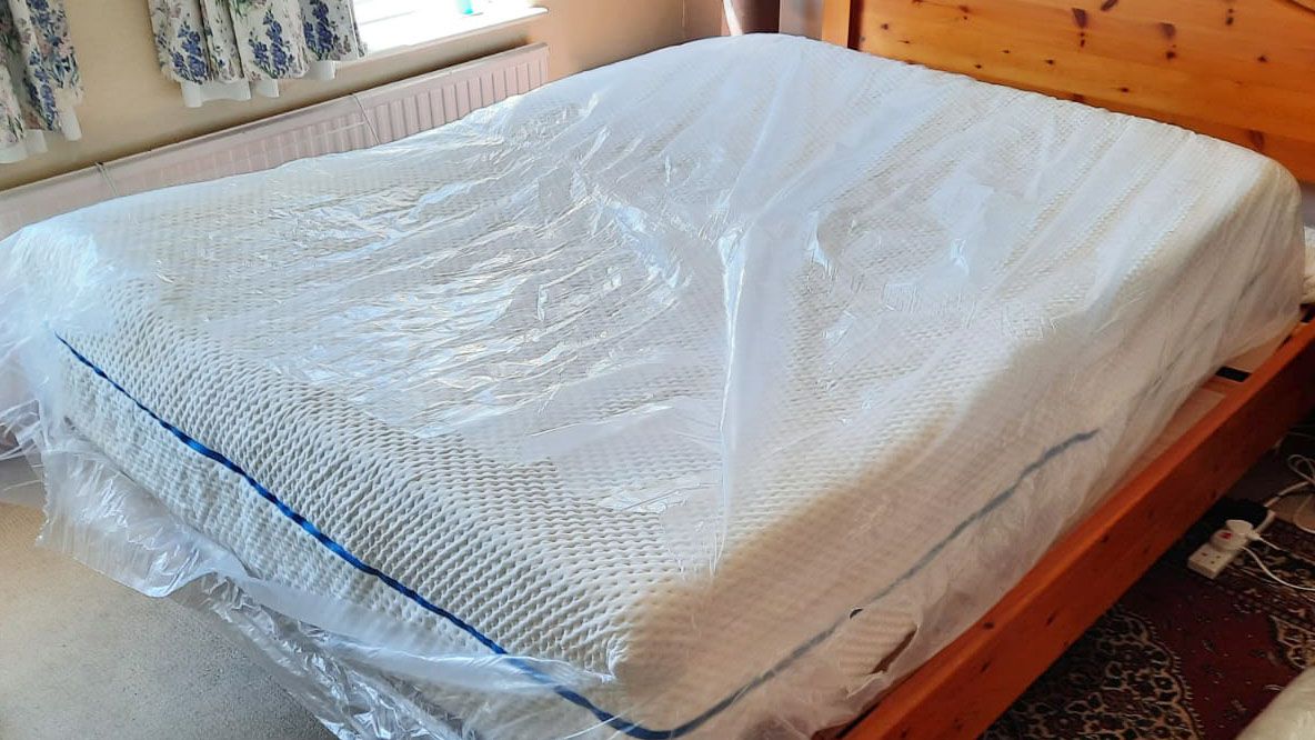 SleepOvation mattress in plastic, on a bed frame