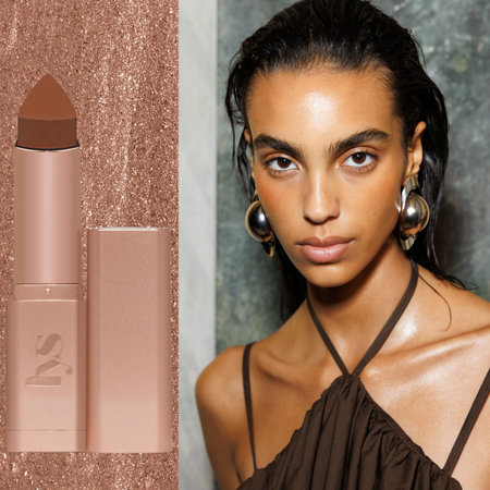 A woman with bronzed skin next to a bronzer stick. 