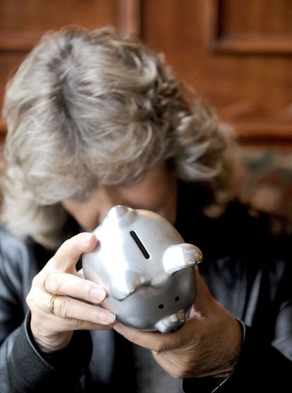 Retired woman using piggy bank
