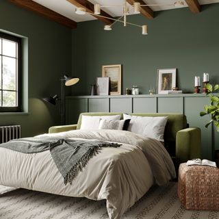 A dark green sofa bed in a green living room