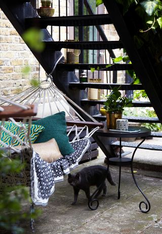 side garden with hammock under steps