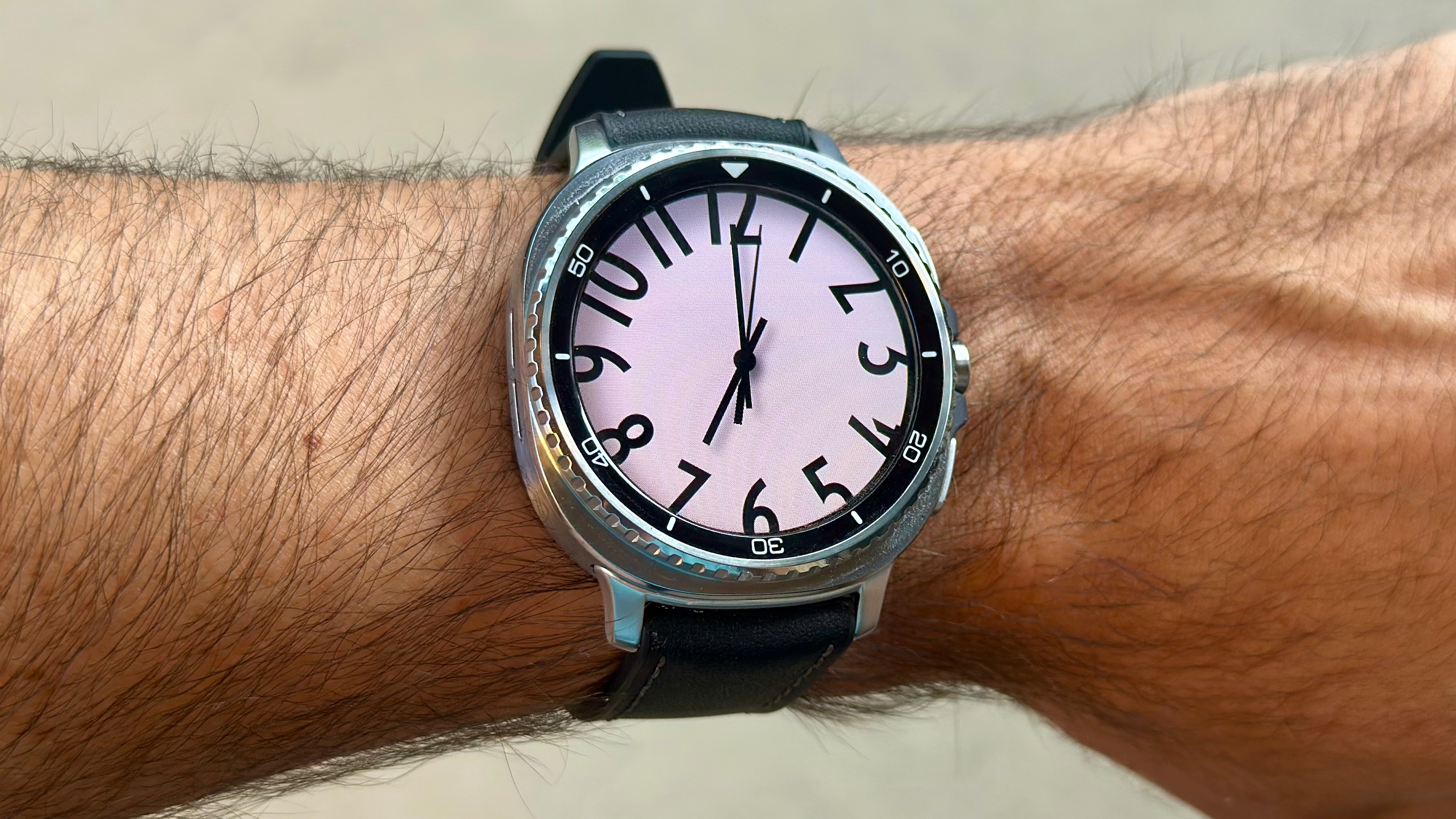 The Samsung Galaxy Watch 8 Classic on a person's wrist, showing a custom watch face from the Pujie app called "TMX AL-WB."
