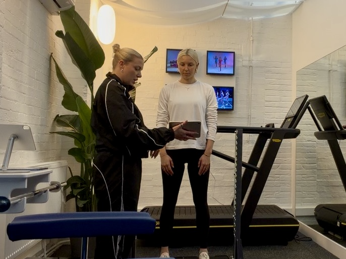 A woman standing on force plates in a longevity testing clinic