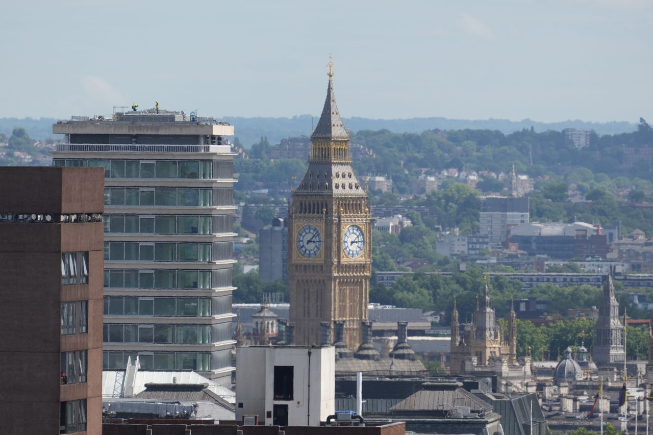 Telephoto view of the Elizabeth Tower rising between buildings in central London.