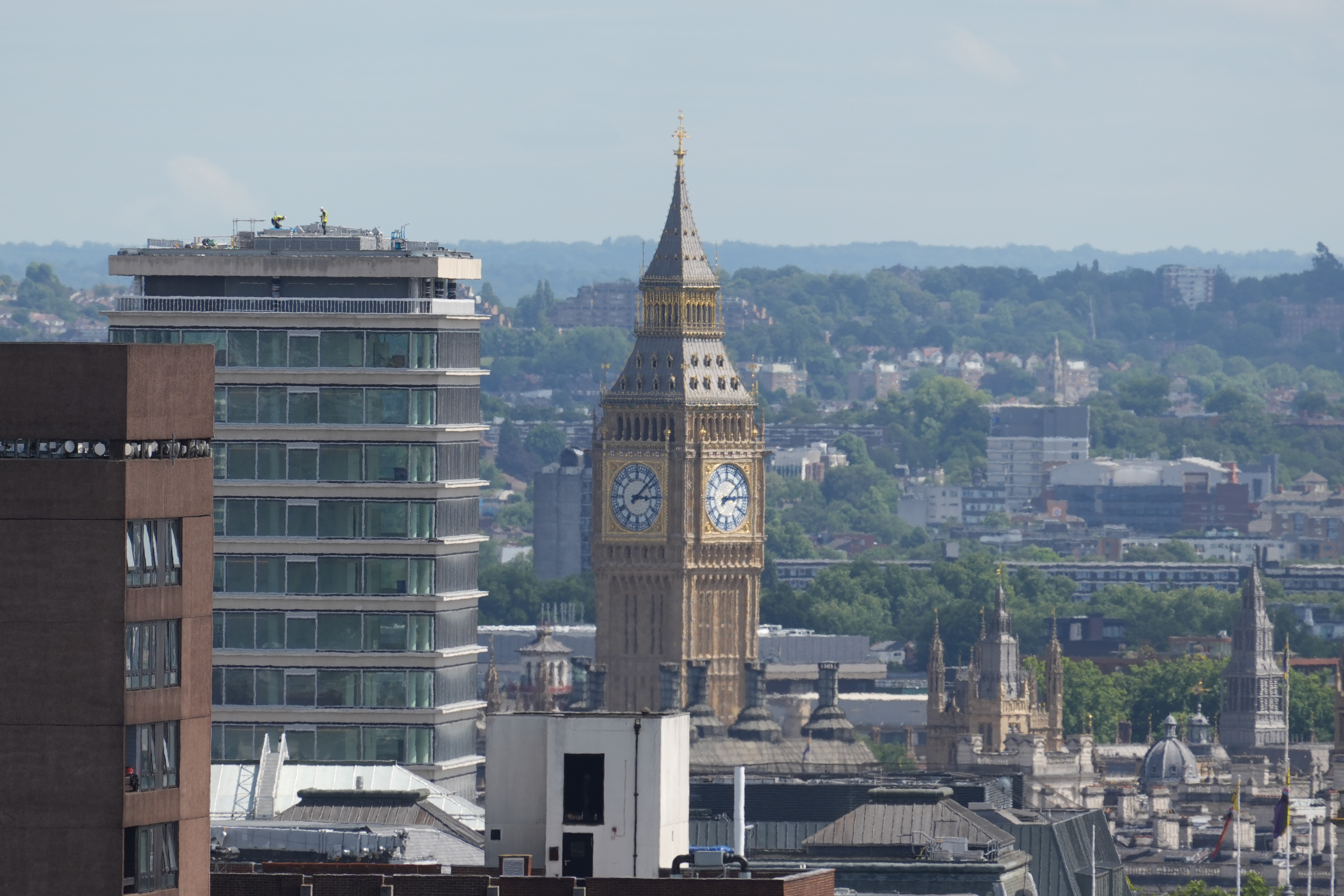 Telephoto view of the Elizabeth Tower rising between buildings in central London.