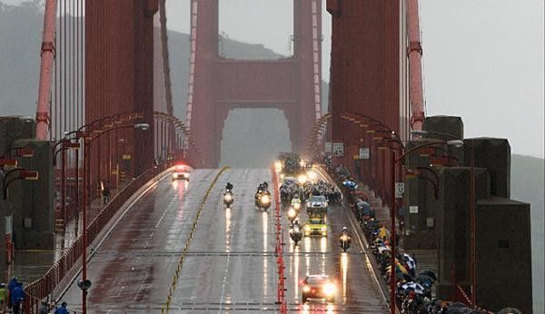 The Golden Gate Bridge dwarfs the peloton.