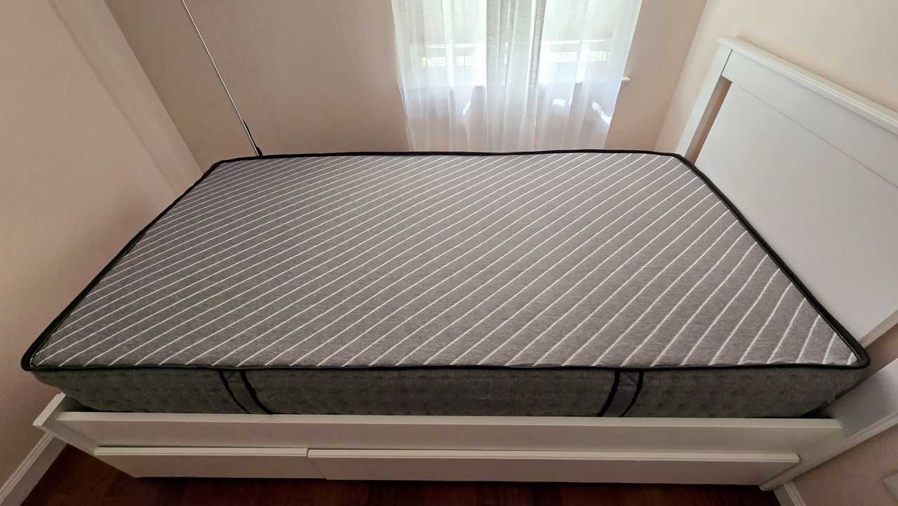 Overview of the Siena Premier Hybrid Mattress in a warm-hued bedroom on a white bed frame with a headboard