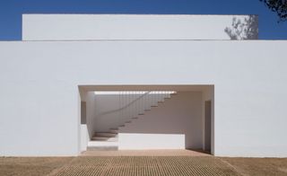 Exterior view of Casa Modesta and the rectangle archway leading to the stairwell under a blue sky