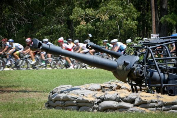 The peloton passes by retired guns along the Fort Gordon route.