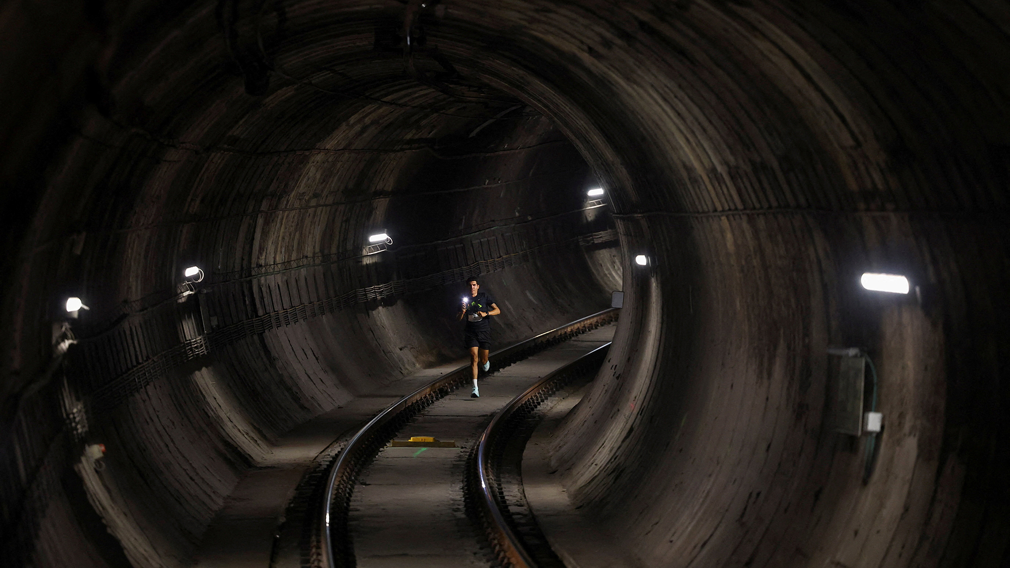 A participant runs through the subway tunnel during a race to commemorate the 100th anniversary of the Barcelona metro, in Barcelona, Spain