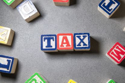 the word tax spelled on on wooden toy blocks 