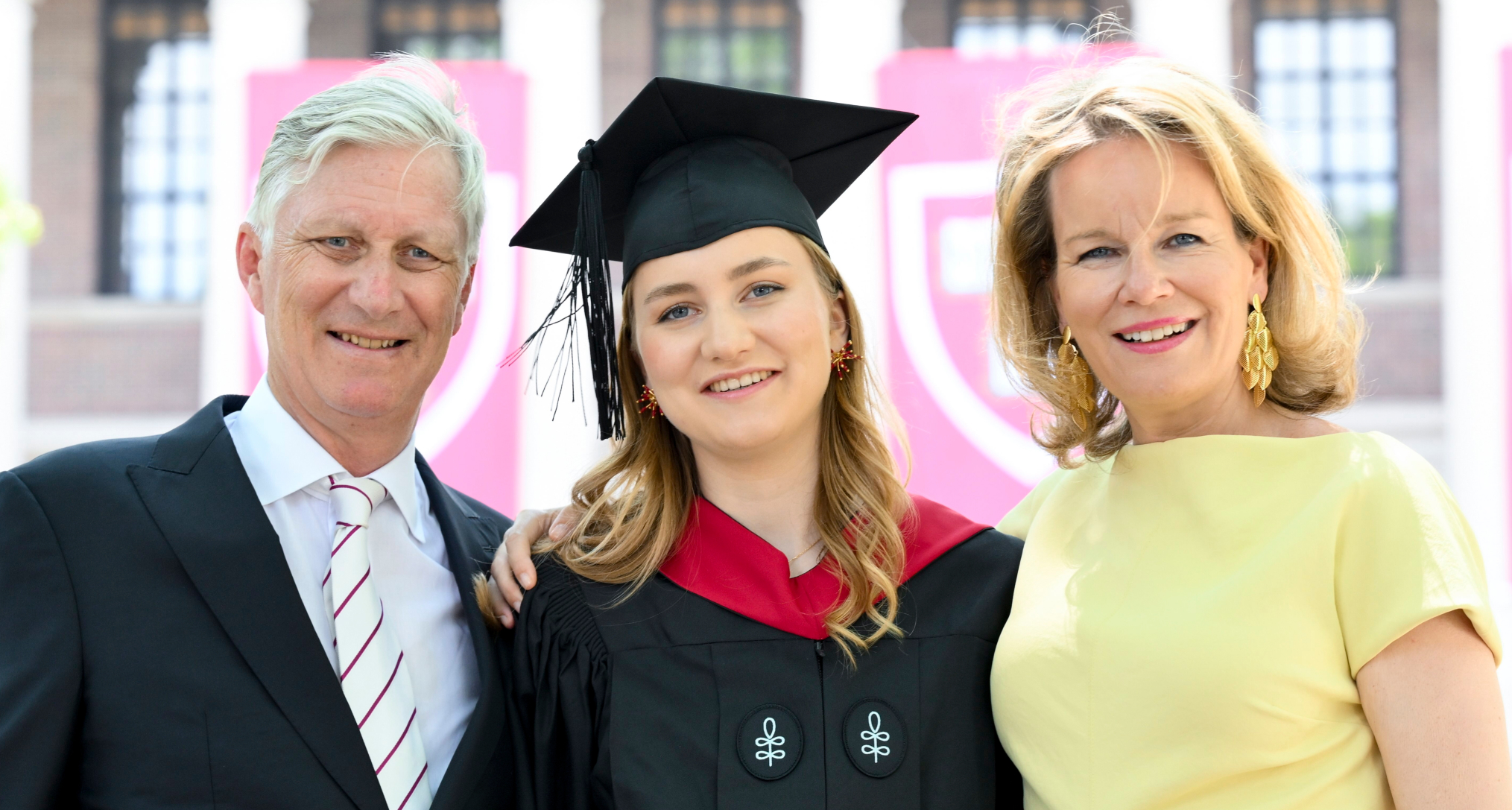 Princess Elisabeth in a graduation cap and gown with King Phillipe and Queen Mathilde