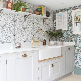 Kitchen with two types of wallpaper, white cabinetry and Belfast sink