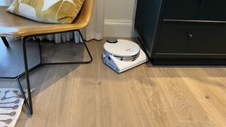 white robot vacuum being tested on hard floors