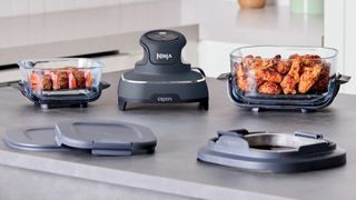 Ninja Crispi air fryer on kitchen counter with food in travel containers