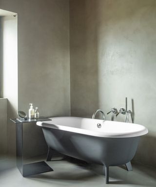 bathroom with gray walls, gray rolltop and metal table