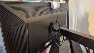 A picture of the Acer Predator X32QFS's rear while mounted on a monitor arm.