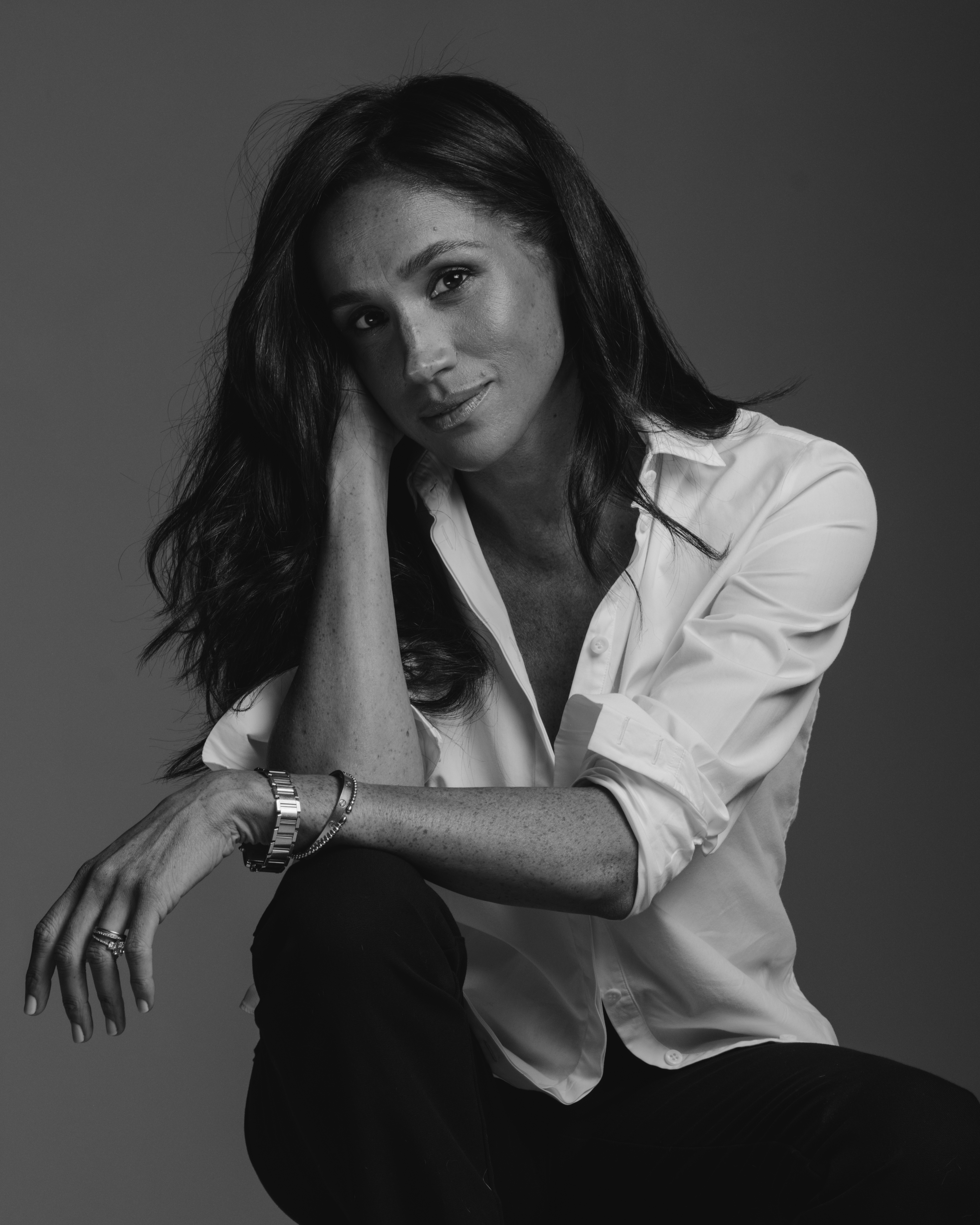 a black and white photo of Meghan Markle wearing a white shirt