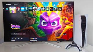 Philips Evnia 42M2N8900 next to PS5 with Spyro Reignited Trilogy on screen