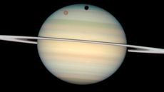 Photo of Saturn with Titan and its shadows across its surface