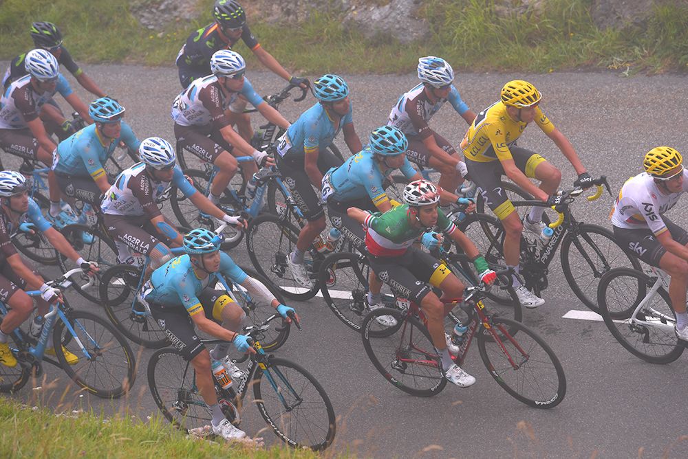 The peloton climbs in the fog during stage 12 at the Tour de France