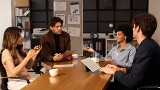 Four people having a meeting with the AINOTE 2 taking notes