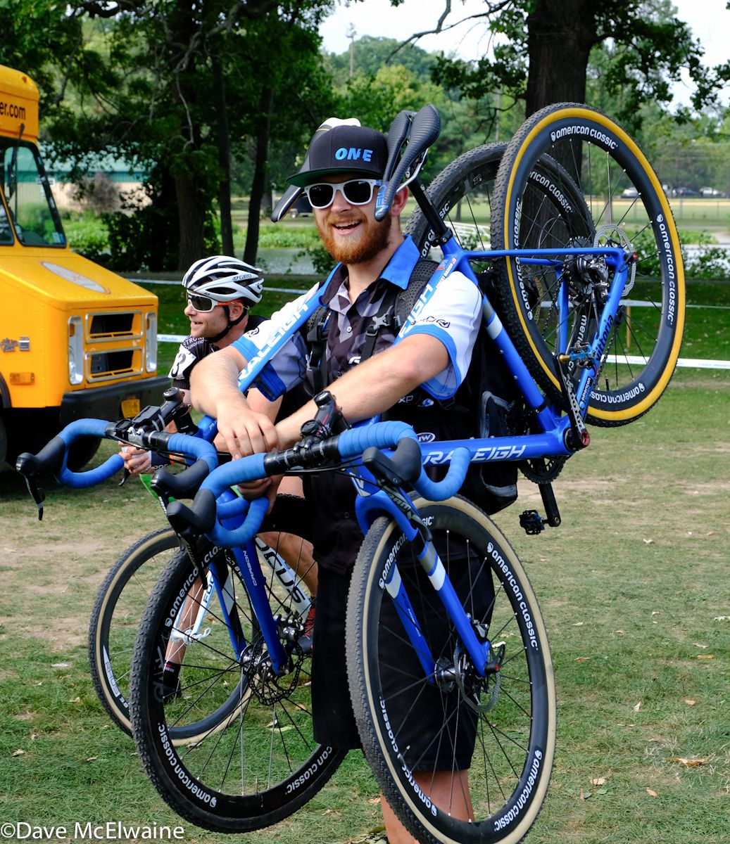 One of the mechanics headed to the pits with spare bikes.