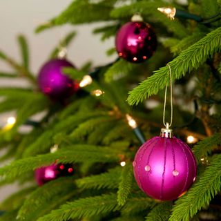 christmas tree with purple baubles and twinkly lights